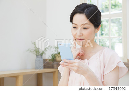 操作智慧型手機的中年婦女 17545092
