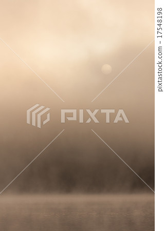 Morning sun through fog at lake 17548198