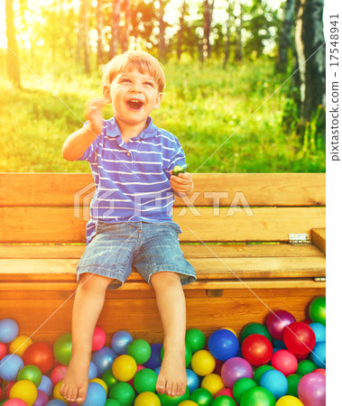 Happy child playing with colorful plastic balls Happy child playing with colorful plastic balls 17548941