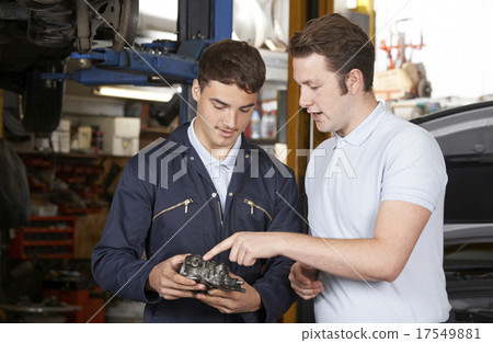 Mechanic Helping Apprentice To Fix Engine 17549881