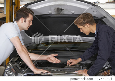 Mechanic Helping Apprentice To Fix Engine 17549891