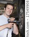 Mechanic In Garage Using Air Hammer On Car Wheel 17549908