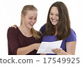 Studio Shot Of Two Female Teenage Friends Celebrating Exam Resul 17549925