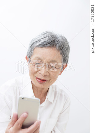 80-year old grandma who watches smart phone white back 17550021