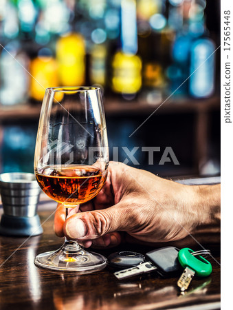 Alcoholism. Cup cognac or brandy hand man the keys 17565448