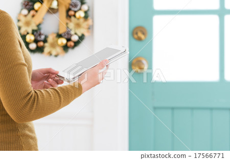 A woman shopping on a tablet during the Christmas season. A woman shopping on a tablet during the Christmas season. 17566771