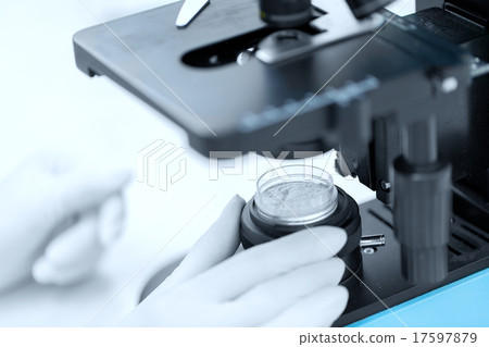 close up of hand with microscope and powder sample close up of hand with microscope and powder sample 17597879