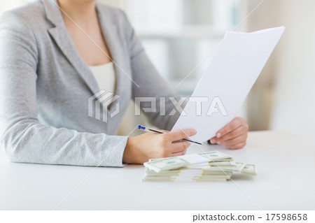 close up of female hands with money and tax report close up of female hands with money and tax report 17598658