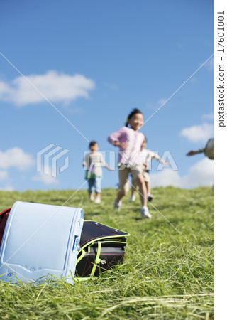 Schoolbags and elementary school students on grassland 17601001