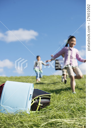 Schoolbags and elementary school students on grassland Schoolbags and elementary school students on grassland 17601002