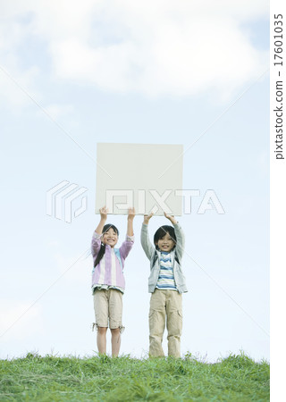 在草地上有留言板和微笑的小學生 17601035