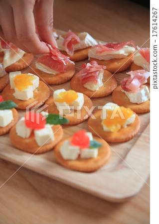 A woman making a cracker snack 17614267