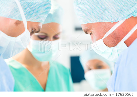 Surgeons operating in operation theater room 17620565