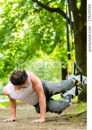 man in city park doing suspension trainer sport 17620568