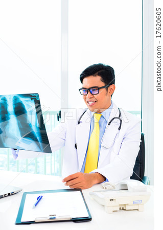 Asian doctor examining x-ray picture in practise 17620605
