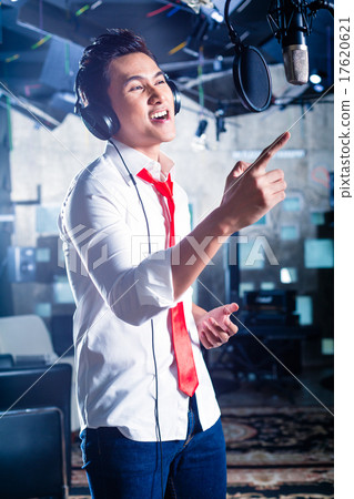 Asian singer producing song in recording studio Asian singer producing song in recording studio 17620621