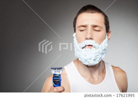 Handsome young fit bearded man with shaver Handsome young fit bearded man with shaver 17621995