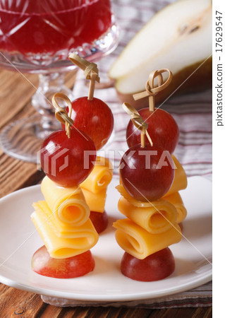 Red grapes and cheese on skewers close-up vertical 17629547