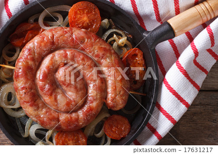 Fried sausage with onions in a pan macro top view 17631217