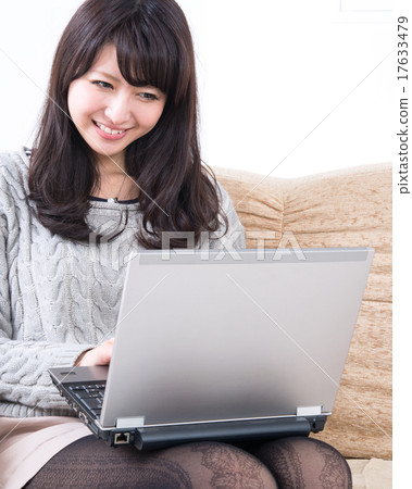 一位操作筆記本電腦的年輕女士 一位操作筆記本電腦的年輕女士 17633479