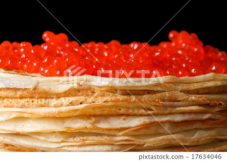 Pile of crepes with red caviar isolated on black 17634046