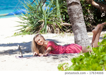 Blond girl with a laptop on tropical beach 17634888