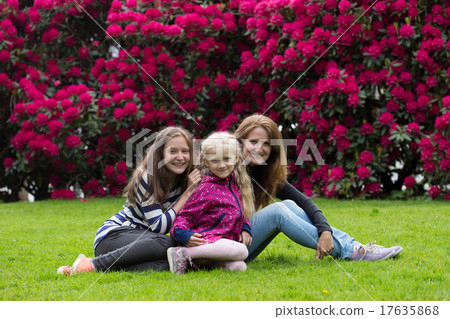 mother with daughters sitting on a grass mother with daughters sitting on a grass 17635868