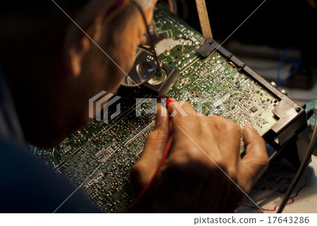 Engineer Looking at a Motherboard of an Analog TV 17643286
