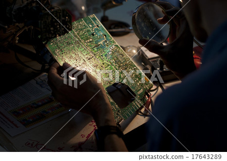 Engineer Looking at a Motherboard of an Analog TV 17643289