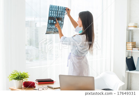 Doctor woman with white labcoat looking at x-ray 17649331