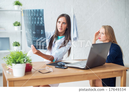 Doctor woman with white labcoat looking at x-ray 17649334