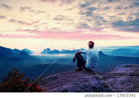 Adult sportsman in white shirt sit on sharp cliff Adult sportsman in white shirt sit on sharp cliff 17653591