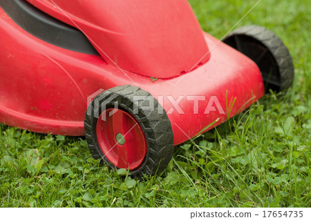 red lawnmower on green grass 17654735