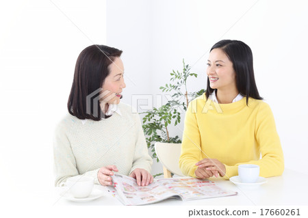 聊天的兩名婦女,當觀看雜誌時 聊天的兩名婦女,當觀看雜誌時 17660261