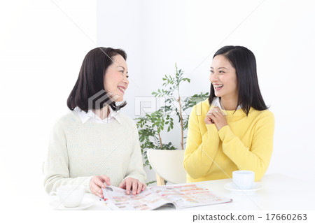 聊天的兩名婦女,當觀看雜誌時 聊天的兩名婦女,當觀看雜誌時 17660263
