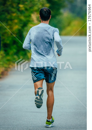athlete runs on the road from asphalt 17676964