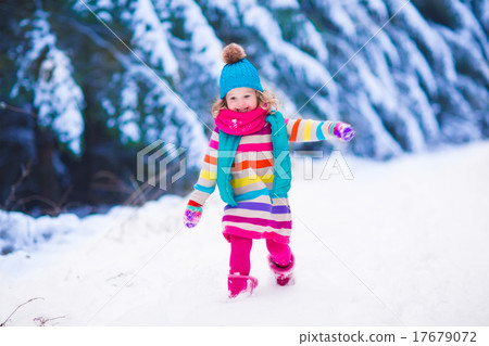 Little girl playing in snowy winter forest Little girl playing in snowy winter forest 17679072