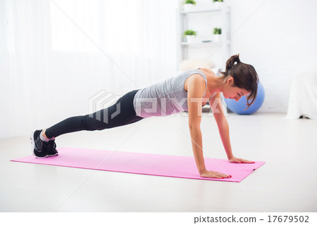 fit woman doing push-ups on the floor in her fit woman doing push-ups on the floor in her 17679502