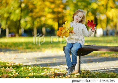 Adorable little girl having fun on autumn day Adorable little girl having fun on autumn day 17680169