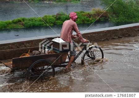 雨季的印度首都德里印第安人在洪水中騎自行車 雨季的印度首都德里印第安人在洪水中騎自行車 17681807