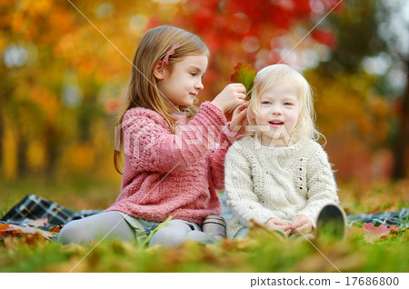 Two sisters having fun together in autumn park Two sisters having fun together in autumn park 17686800