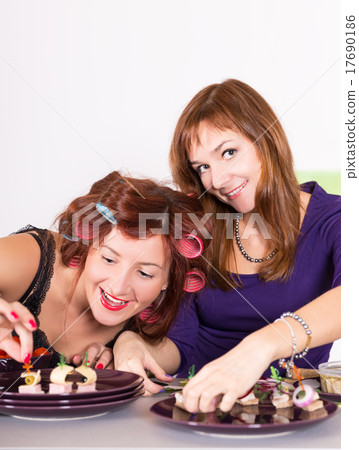 Two young woman housewife cooking curlers hair Two young woman housewife cooking curlers hair 17690186