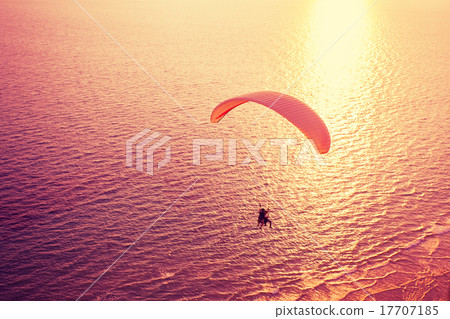 Silhouette of paraglider soaring over sea 17707185