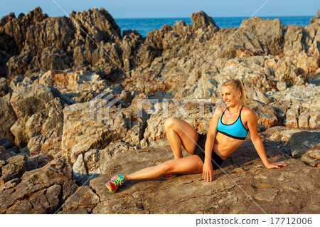 Athlete woman doing sport exercising on the rocks by the sea Athlete woman doing sport exercising on the rocks by the sea 17712006