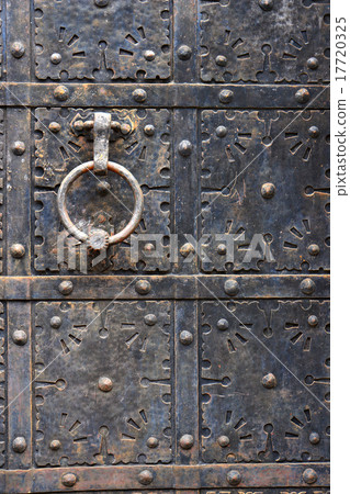 Old door handle on iron medieval door. 17720325