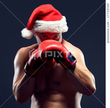 Christmas fitness boxer wearing santa hat boxing on black background Christmas fitness boxer wearing santa hat boxing on black background 17728589