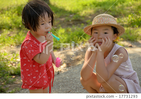 Sister blowing soap bubble Sister blowing soap bubble 17731293