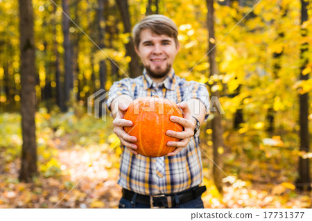 Smiling man carrying pumpkin outdoors Smiling man carrying pumpkin outdoors 17731377