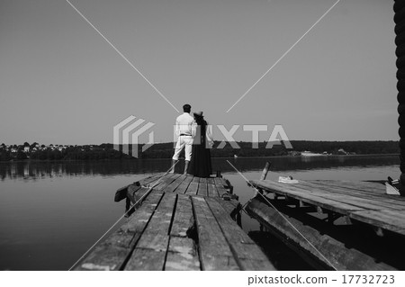 Hugging man and woman in love on wooden pier Hugging man and woman in love on wooden pier 17732723
