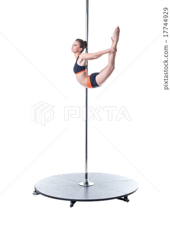 Pole dance. Charming girl performs complex element 17744929